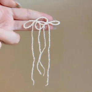 Dettaglio macro di orecchini a fiocco in perle con eleganti nappine lunghe oggi.