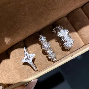 Close-up of three elegant zirconia open rings in a brown velvet jewelry box display.