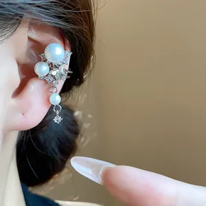 Elegant close-up detail of a zircon star and pearl ear cuff shown on model's ear