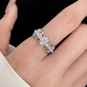 Close-up detail of an elegant silver hollow-out ring with dainty pearls and zircons.