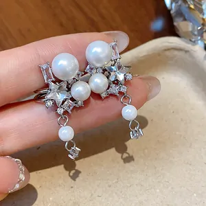 Detailed view of elegant star zircon and pearl drop ear cuff in silver finish.