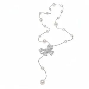 Elegant pearl necklace with cubic zirconia encrusted bow pendant in French retro style.