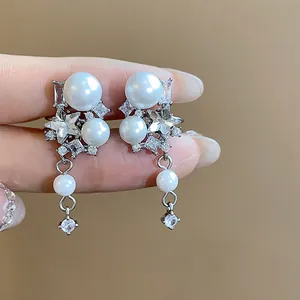 Detailed view of silver-tone ear clips with pearls and star-shaped zircons.
