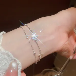 Close-up of elegant double-layered silver bracelet with sparkling flower zircon charms.
