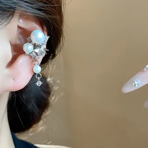 Elegant detail of a Korean style star and pearl ear cuff with sparkling zircon accents.