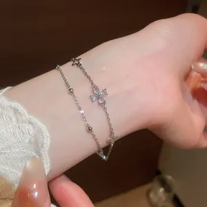 Detailed close-up of a double-layer bracelet with blue zircon flower and star charms