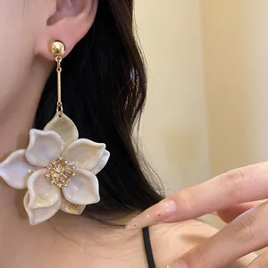 Primer plano de elegantes pendientes colgantes de flores con centro de pedrería