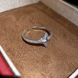 Detailed macro view of a star-shaped zircon pavé open ring inside a luxury brown velvet jewelry box