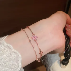 Close-up of elegant double-layered rose gold bracelet with pink zircon flower charms