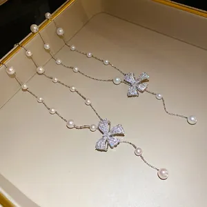 Detail showing elegant zircon bow pendant and pearl beads on vintage clavicle necklace