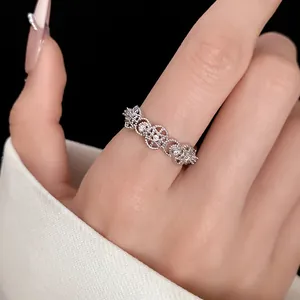Close-up detail of an elegant hollow zircon open ring worn on a finger for women.
