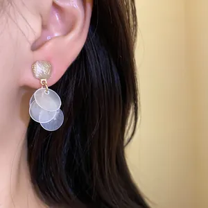 Detail view of Korean style stud earrings with translucent round dangles on ear