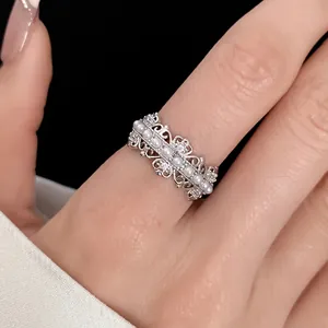 Elegant silver hollow lace ring with small pearls and zircons worn on finger detail view