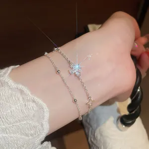 Close-up of silver-tone double-layer bracelet with sparkling zircon flower on wrist