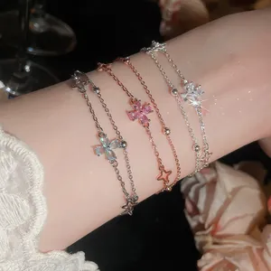 Detail of elegant double-layer bracelets featuring zircon four-leaf flower and star charms.