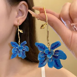Eleganti orecchini pendenti a fiore in smalto blu con lunghi steli dorati, stile retrò