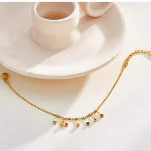 Close-up of a gold stainless steel bracelet featuring colorful zircon and bead charms