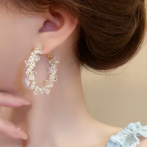 Elegant beaded wrapped hoop earrings with pearls and clear crystals on gold wire.