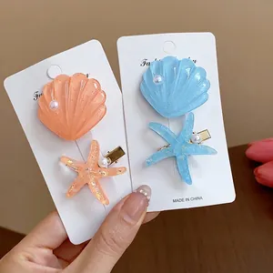 Beach style resin starfish and seashell hair clips set with pearls on display card