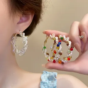 Macro view showing the intricate colorful bead wrapping on stylish hoop earrings