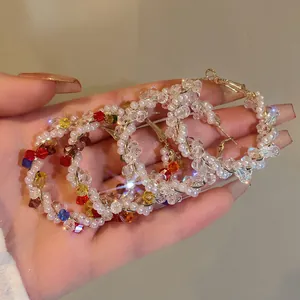 Macro view showing the intricate detail of colorful beaded hoop earrings with white pearls