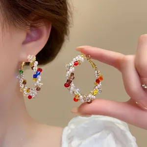 Detailed close-up of vibrant colorful beaded hoop earrings with pearls and crystals