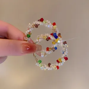 Close-up of vibrant dopamine style colorful beaded hoop earrings with pearls and crystals