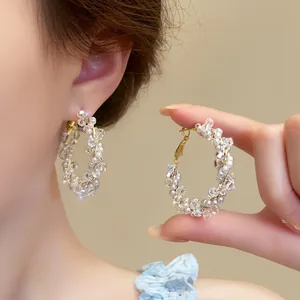 Detailed view of intricate crystal bead and pearl wrapped golden hoop earrings for women.