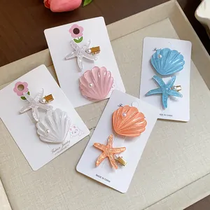 Detail view of colorful resin starfish and seashell hair clips with pearls and glitter