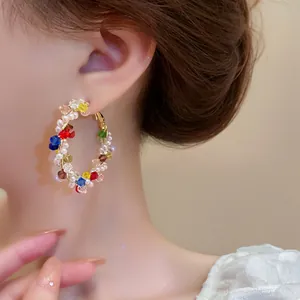 Detailed close-up of vibrant multicolored beaded hoop earring worn by a model