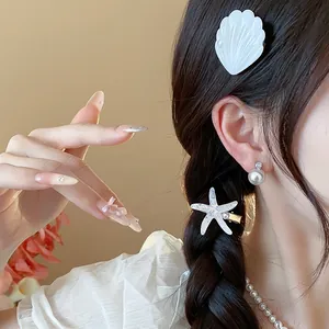 Detailed view of white resin starfish and shell hair clips with elegant pearl accents