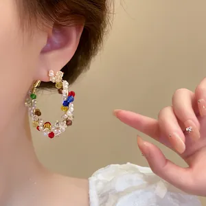 Close-up of colorful beaded hoop earrings featuring multi-colored crystals and pearls