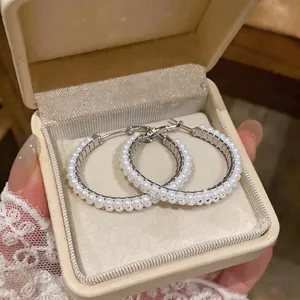 Elegant silver hoop earrings with double-row white pearls presented in a jewelry box