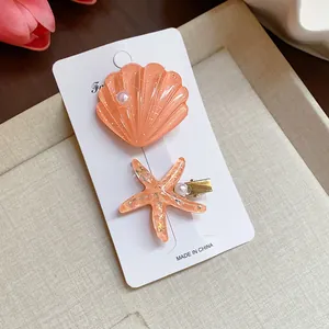 Detail of resin starfish and shell hair clips with glitter finish for beach vacations.