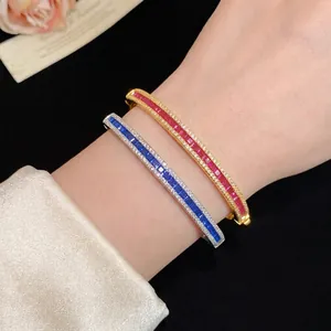 Vintage style gold and silver bangles with vibrant red and blue zircon crystals.