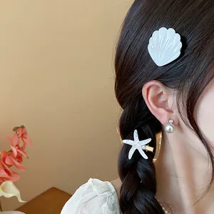 Detail view of resin starfish and shell hair clips on braided hair for beach holiday