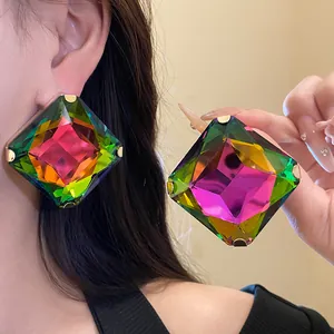 Close-up of oversized square colorful crystal earrings with faceted design