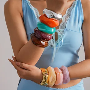 Macro view of colorful dopamine resin and metallic irregular geometric bangles on wrist