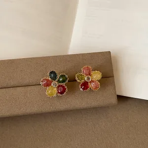 Dettaglio di orecchini a lobo a forma di fiore colorato con texture jelly