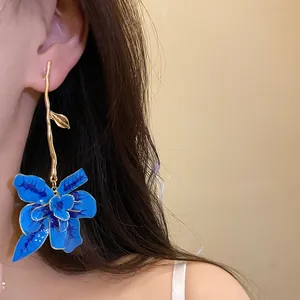 Vista dettagliata di un elegante orecchino a fiore in smalto blu con gambo dorato