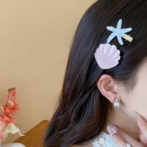Close-up detail of elegant resin starfish and seashell hair clips on long wavy hair