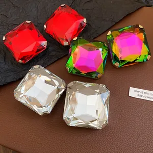 Close-up of square diamond-studded stud earrings in red, multi-color, and clear