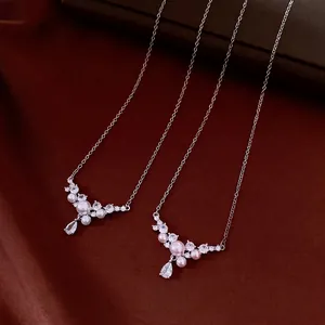 Elegant water-drop zircon and pearl necklaces shown on a luxurious dark red silk background.