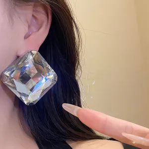 Close-up of oversized square crystal stud earring with sparkling rhinestone detail