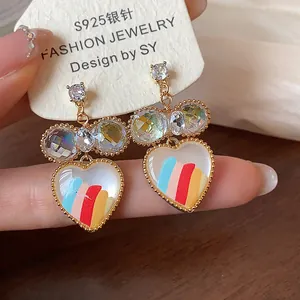 Vue rapprochée de boucles d'oreilles en cœur avec rayures colorées et placage en or 18k