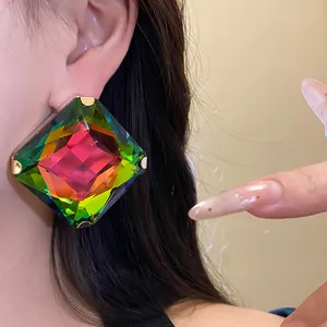 Close-up detail of a vibrant multi-colored faceted square crystal stud earring on ear