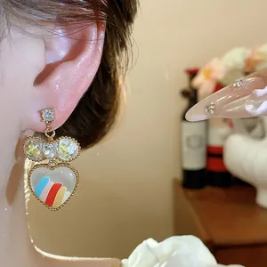 Gros plan de boucles d'oreilles cœur plaquées or 18 carats avec motif arc-en-ciel coloré