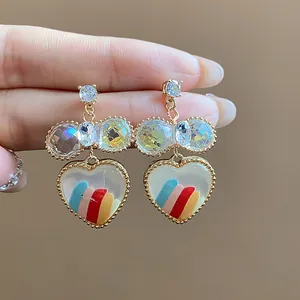 Gros plan de boucles d'oreilles plaquées or en forme de cœur avec incrustation