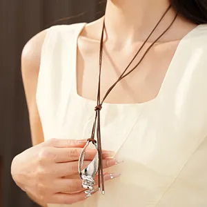 Dettaglio di una collana con ciondolo a conchiglia in argento su cordino in cuoio marrone