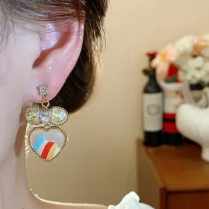 Gros plan détaillé d'une boucle d'oreille cœur plaquée or 18 carats avec nœud au verre